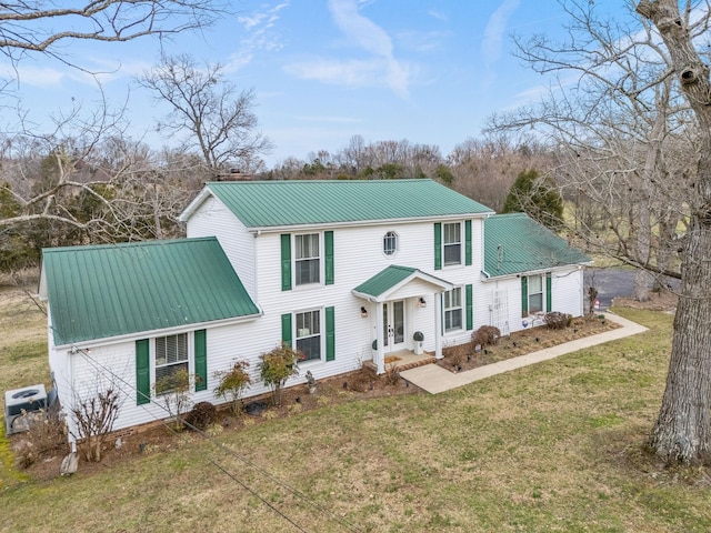 colonial inspired home featuring metal roof, a front lawn, and french doors