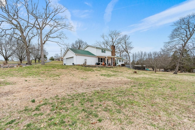 view of yard featuring covered porch and a garage