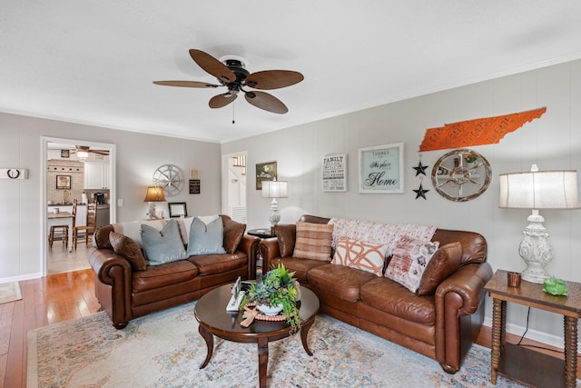 living area with ceiling fan, ornamental molding, and hardwood / wood-style flooring