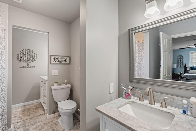 full bath featuring toilet, curtained shower, baseboards, and vanity