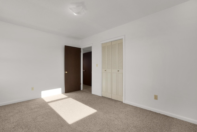 unfurnished bedroom featuring a closet, carpet flooring, and baseboards