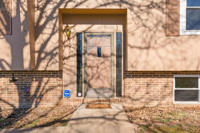 property entrance featuring brick siding