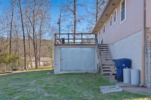 exterior space featuring stucco siding, a yard, stairway, and fence