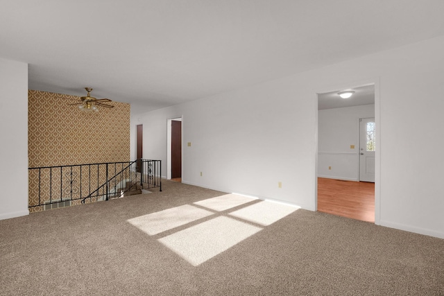 unfurnished room with carpet floors, ceiling fan, and baseboards