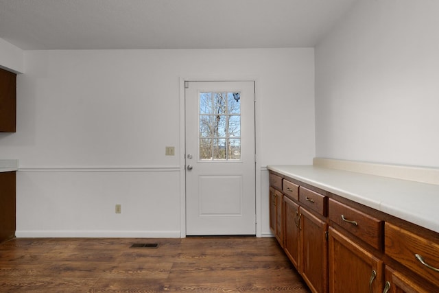 entryway with dark wood-style floors, visible vents, and baseboards