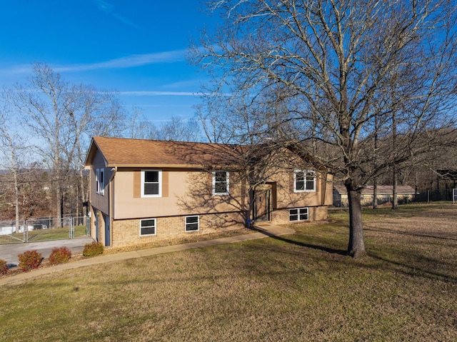 view of front facade featuring brick siding, concrete driveway, a front yard, fence, and a garage