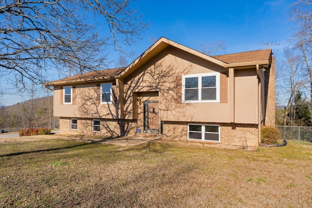 view of front of property with fence, a front lawn, and brick siding