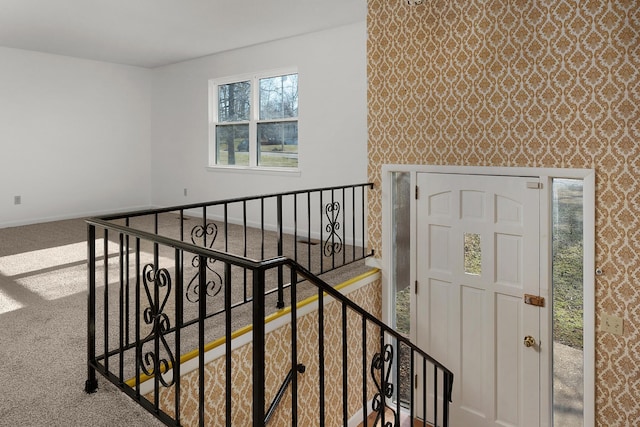 staircase featuring wallpapered walls, carpet flooring, and baseboards