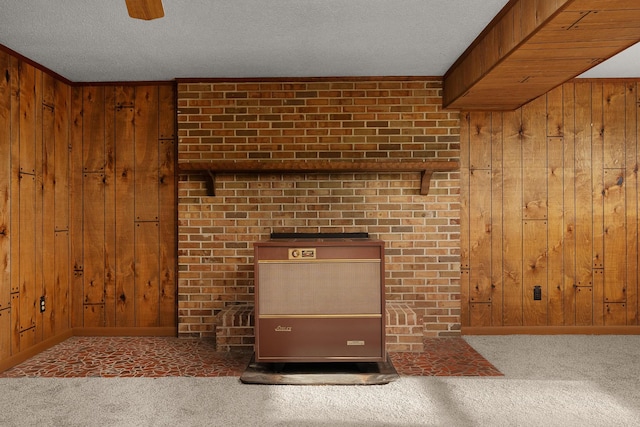 room details featuring ceiling fan, a textured ceiling, wooden walls, carpet flooring, and baseboards