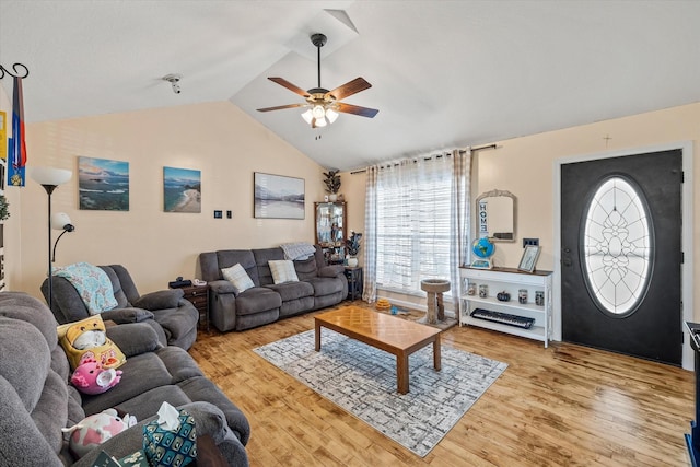 living area featuring vaulted ceiling, light wood-style flooring, and a ceiling fan