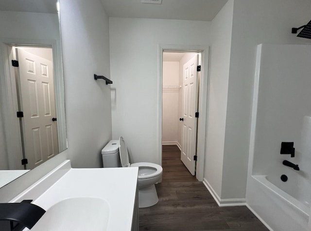 bathroom featuring baseboards, visible vents, toilet, wood finished floors, and vanity