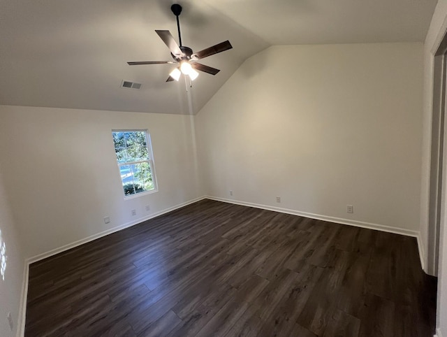 interior space featuring lofted ceiling, a ceiling fan, visible vents, baseboards, and dark wood-style floors