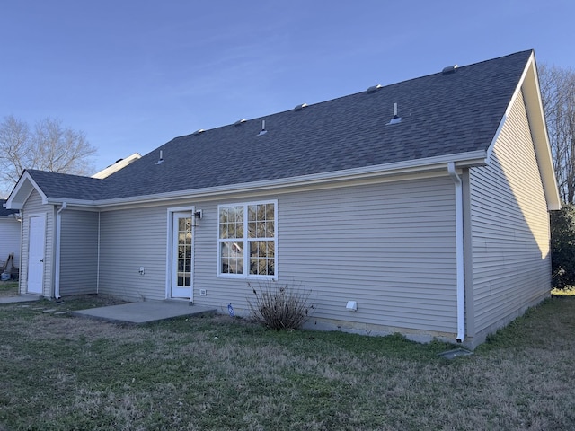 back of property featuring a patio area, roof with shingles, and a yard