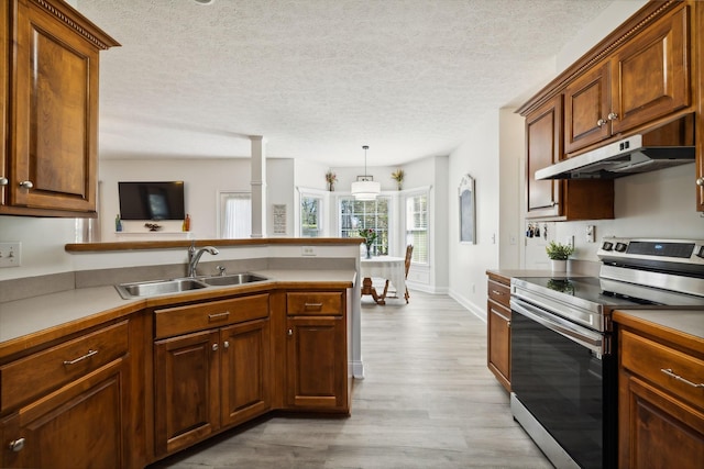 kitchen with light wood-style flooring, a sink, a peninsula, under cabinet range hood, and stainless steel electric range