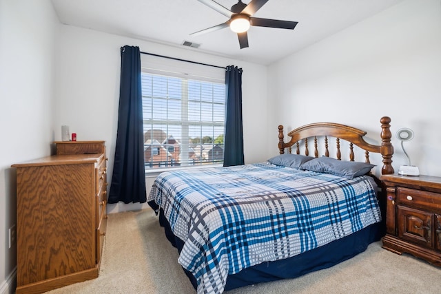 bedroom with visible vents, a ceiling fan, and light colored carpet