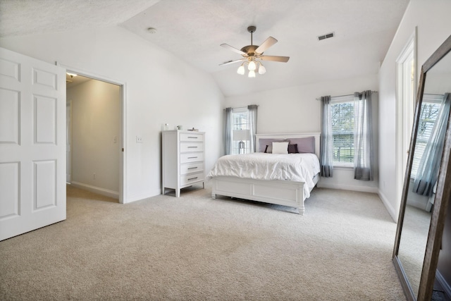 bedroom featuring lofted ceiling, ceiling fan, light colored carpet, visible vents, and baseboards