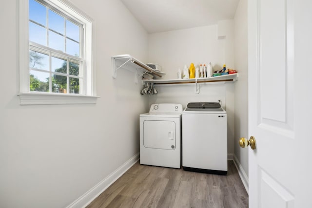 washroom with laundry area, baseboards, light wood-style floors, and washer and dryer