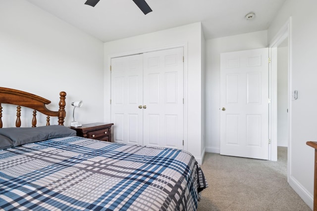 carpeted bedroom featuring a closet, ceiling fan, and baseboards