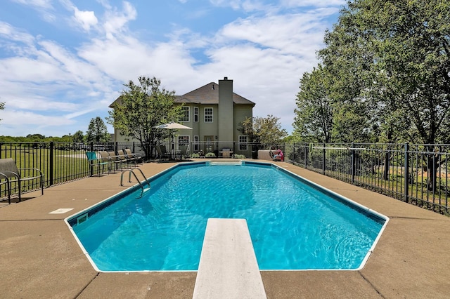 view of swimming pool with fence, a diving board, and a fenced in pool