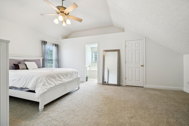 bedroom with carpet flooring, vaulted ceiling, ceiling fan, ensuite bath, and baseboards