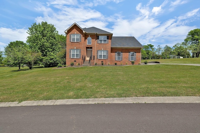 colonial-style house featuring a front yard, crawl space, and brick siding