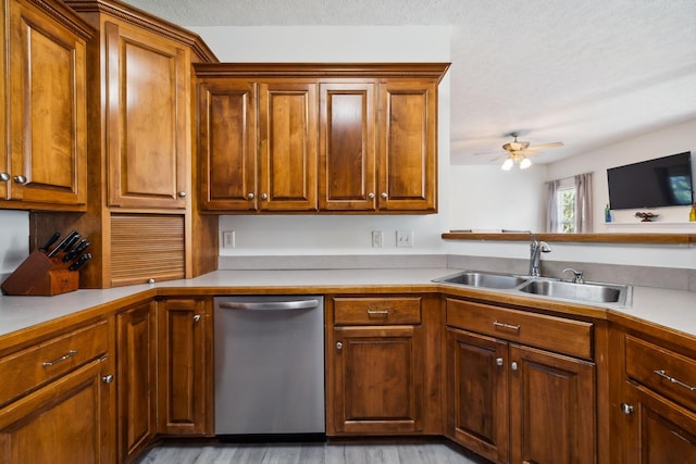 kitchen with a textured ceiling, a sink, a ceiling fan, light countertops, and stainless steel dishwasher