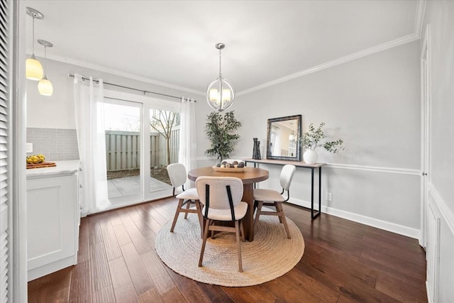 dining space with ornamental molding, a notable chandelier, dark wood finished floors, and baseboards