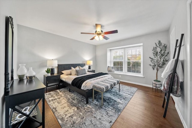 bedroom with dark wood-style floors, baseboards, and a ceiling fan