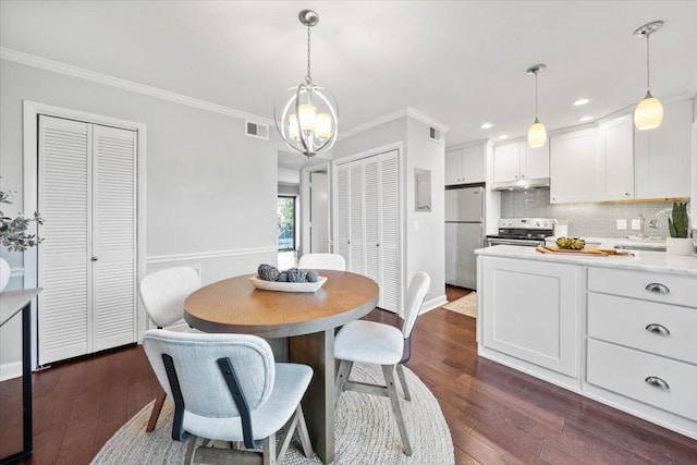 dining room with dark wood-style floors, ornamental molding, visible vents, and recessed lighting