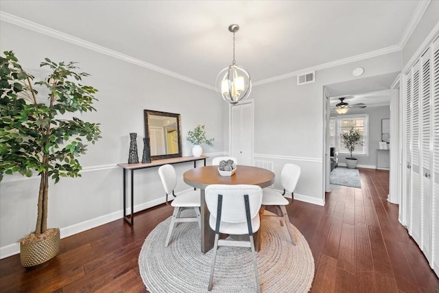 dining space featuring crown molding, dark wood-style flooring, visible vents, and baseboards