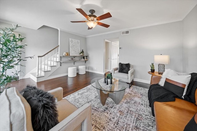 living area with baseboards, visible vents, stairway, wood finished floors, and crown molding