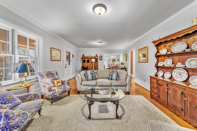 living area with crown molding, light wood-style flooring, and baseboards