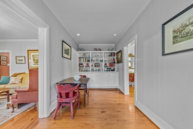 dining space with light wood finished floors and ornamental molding