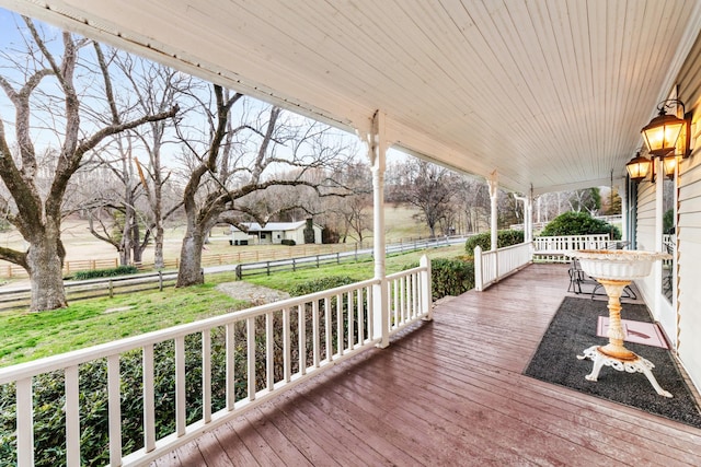 deck with covered porch, fence, and a lawn