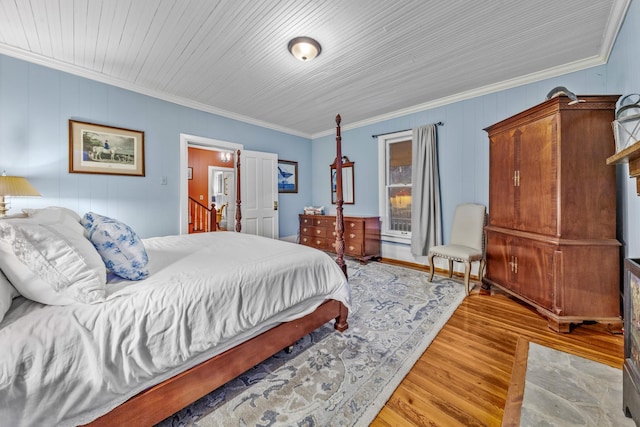 bedroom with ornamental molding and wood finished floors