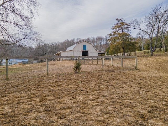 view of yard featuring an outbuilding, a barn, and fence