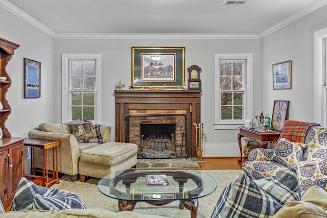 living area with a fireplace, plenty of natural light, wood finished floors, and crown molding