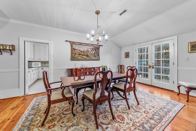 dining space with visible vents, vaulted ceiling, crown molding, french doors, and light wood-type flooring