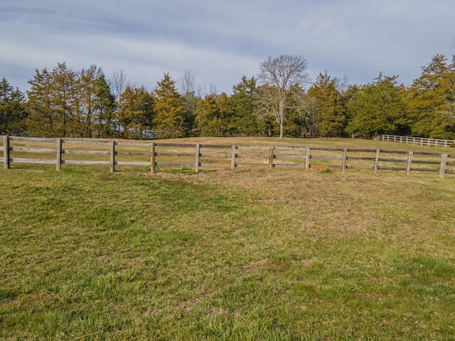 view of yard with a rural view and fence