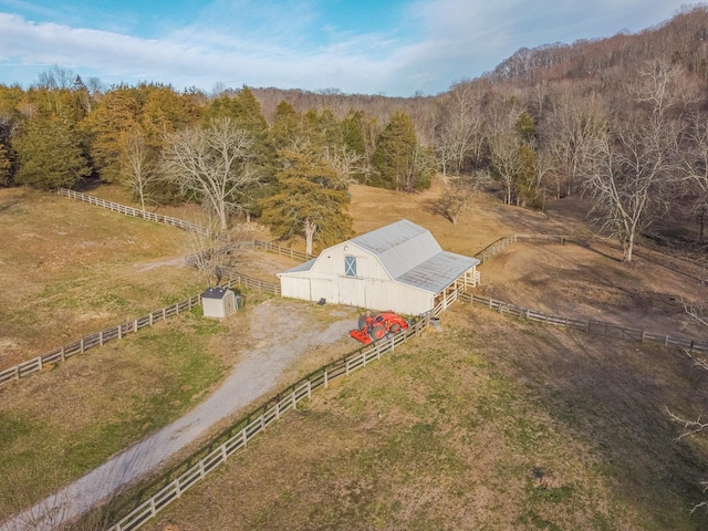 birds eye view of property featuring a rural view and a wooded view