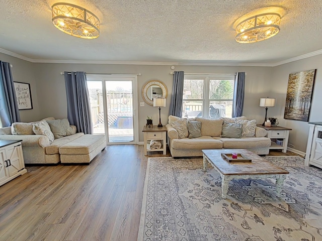 living area with a textured ceiling, light wood-type flooring, a wealth of natural light, and crown molding