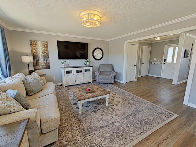 living area with a textured ceiling, ornamental molding, and wood finished floors