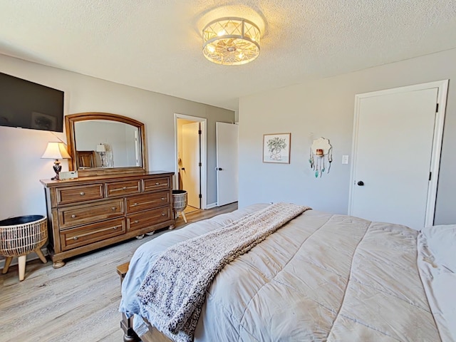 bedroom featuring light wood-style floors and a textured ceiling