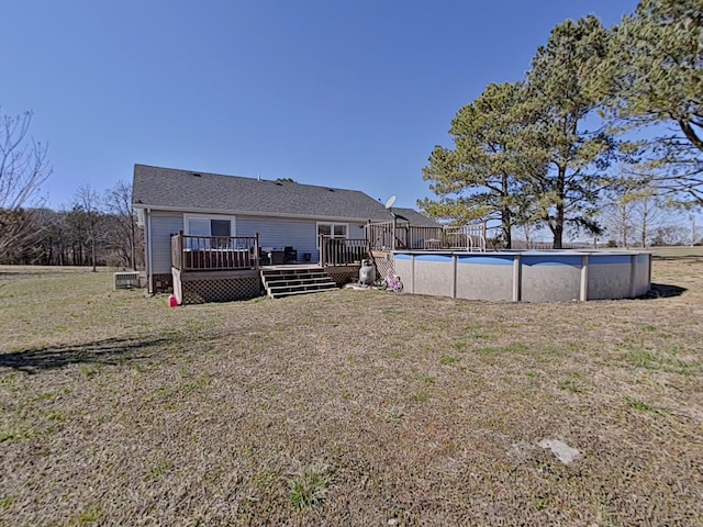 back of house featuring a yard, an outdoor pool, and a wooden deck