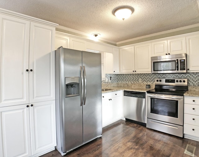 kitchen with appliances with stainless steel finishes, dark wood finished floors, light stone counters, and decorative backsplash