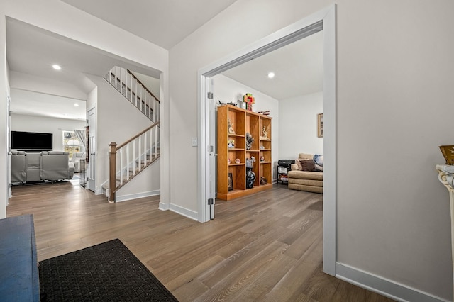 foyer featuring stairs, wood finished floors, and baseboards