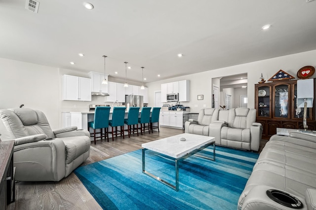 living room featuring recessed lighting, visible vents, and light wood-style floors