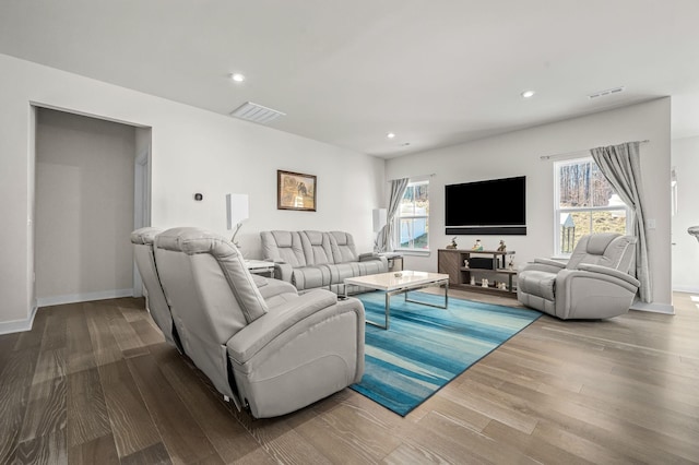 living room with baseboards, visible vents, wood finished floors, and recessed lighting