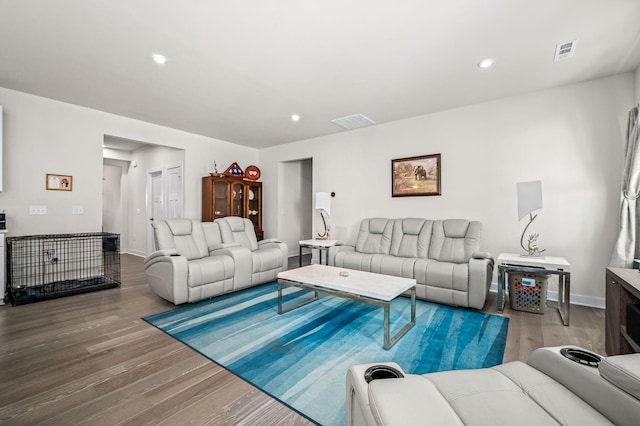 living room with baseboards, visible vents, wood finished floors, and recessed lighting