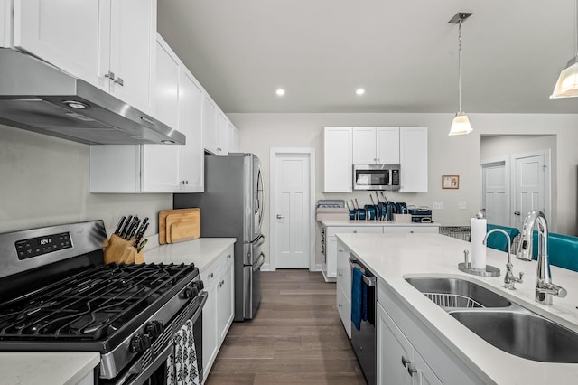 kitchen featuring white cabinets, appliances with stainless steel finishes, light countertops, under cabinet range hood, and a sink